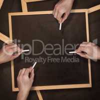 Composite image of multiple hands writing with chalk