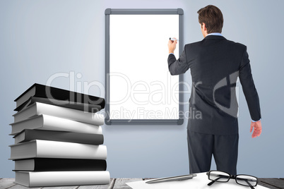 Composite image of businessman standing back to camera writing with marker
