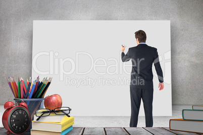 Composite image of businessman standing back to camera writing with marker