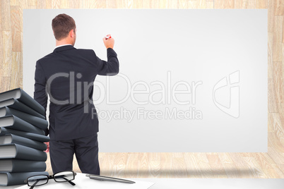 Composite image of business man writing with chalk