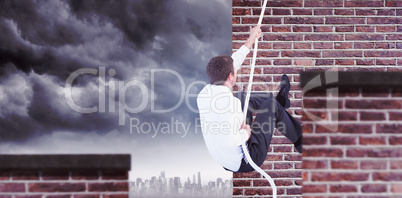 Composite image of businessman pulling a rope with effort