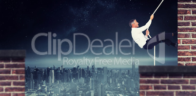 Composite image of businessman pulling rope while sitting on cube