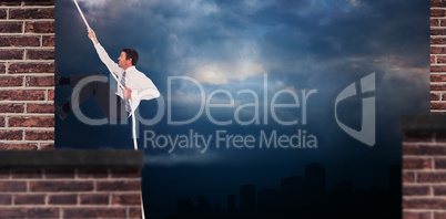 Composite image of businessman pulling a rope