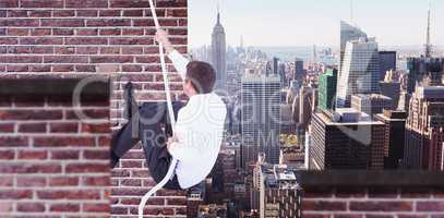 Composite image of businessman pulling a rope with effort