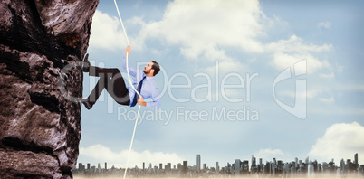 Composite image of businessman pulling a rope with effort