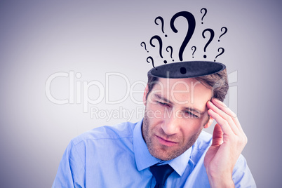 Composite image of stressed businessman holding his head