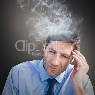 Composite image of stressed businessman holding his head