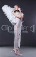 Charming woman in angel costume hovers above floor