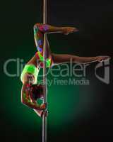 Image of slender girl hanging upside down on pylon