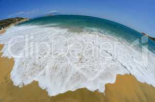 Golden sandy beach with white waves