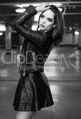 Fashionable young brunette woman posing wearing leather skir