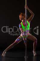 Sexy pole dancer with glowing patterns on her body