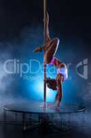 Pole dance. Flexible girl doing handstand