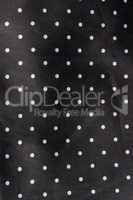 black fabric background with white dots
