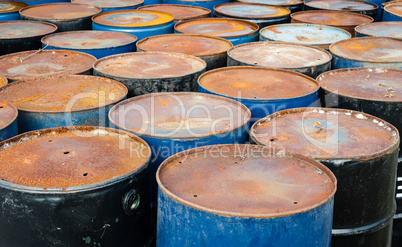 Tops of many rusted storage drums.