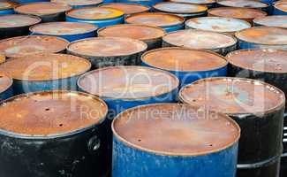 Tops of many rusted storage drums.