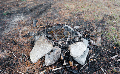 Used fire pit with stones and cinders.