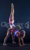 Pole dance. Flexible dancers doing acrobatic stunt