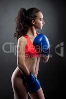 Nude. Beautiful young woman in boxing gloves