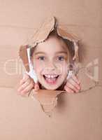 kid portrait in torn paper hole