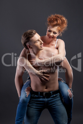Loving couple posing in studio, on gray background