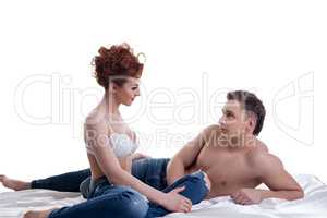 Young lovers posing in bed. Isolated on white