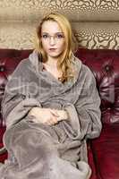 Woman in bathrobe on the sofa