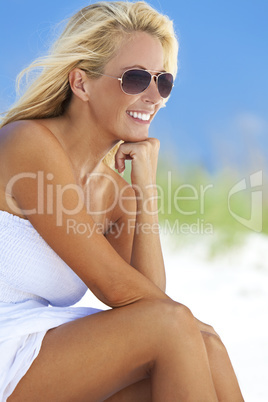 Beautiful Blond Woman in White Dress and Sunglasses At Beach