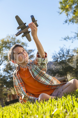 Young Boy Playing WIth Toy Model Airplane Outside