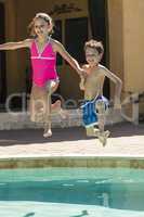 Boy and Girl Children Jumping into Swimming Pool