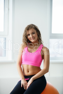 Shot of smiling young woman posing in fitness room