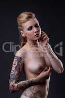 Portrait of beautiful tattooed girl posing nude