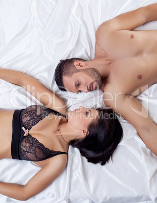 Top view of beautiful loving couple lying in bed