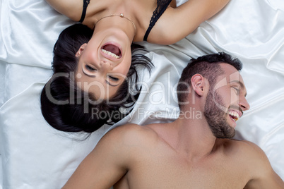 Top view of loving couple laughing in bed