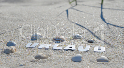 Urlaub Strand Buchstabend im Sand