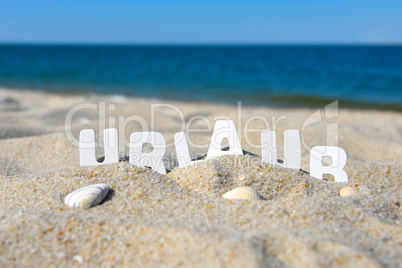 Urlaub Strand Buchstabend im Sand