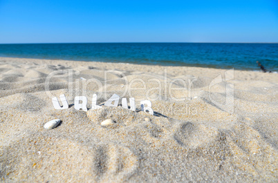 Urlaub Strand Buchstabend im Sand