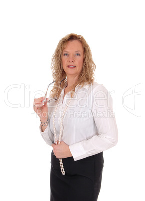 Business woman standing holding her glasses.