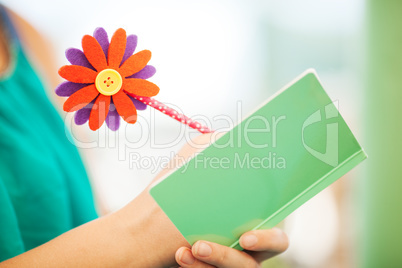 Woman Writing in Notebook with Flower Pencil