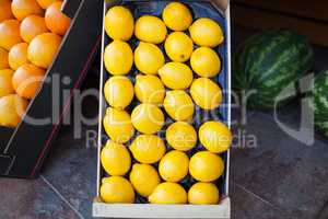 Fresh lemons in an open cardboard box for sale