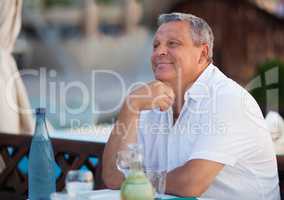Smiling pensive middle-aged man at a restaurant