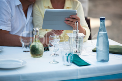Middle-aged couple using a tablet at the table