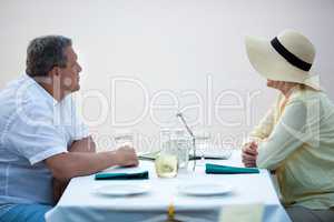 Side view of adult couple sitting at table with wine
