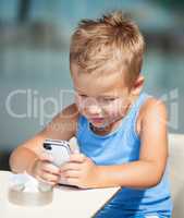 Portrait of blond kid using cell phone