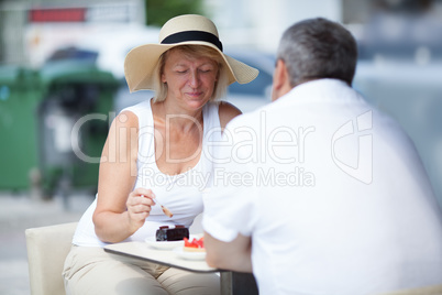 Elderly couple eating in outdoor cafe
