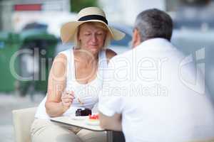 Elderly couple eating in outdoor cafe