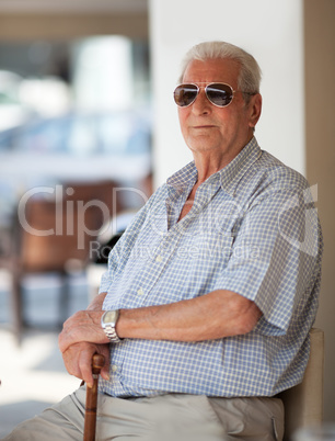 Senior man in sunglasses sitting waiting