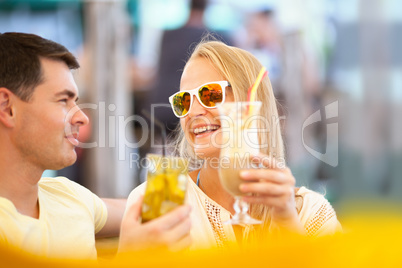 Happy couple drinking cocktails outdoor