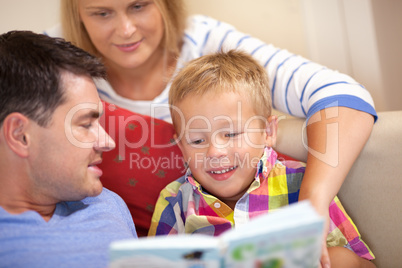 Young family reading a book together