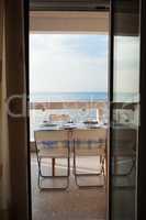 Dining table set on a balcony overlooking the sea